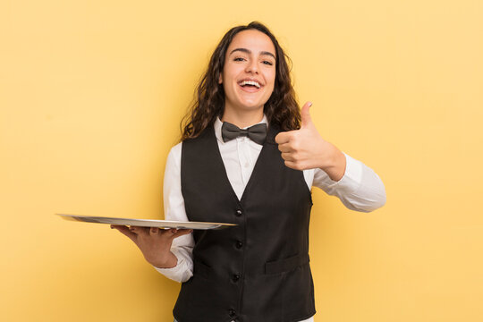 young pretty hispanic woman feeling cross,showing thumbs down. waiter and tray concept