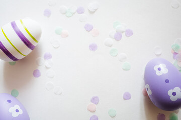 painted easter purple eggs with ornament and decor on white light pastel background.