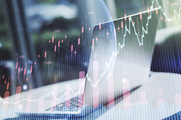 Multi exposure of abstract creative financial graph with world map on modern laptop background, forex and investment concept