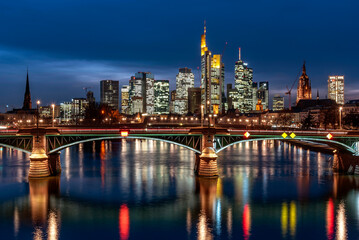 Naklejka na ściany i meble Skyline von Frankfurt am Main in der Dämmerung mit Ignatz-Bubis-Brücke im Vordergrund