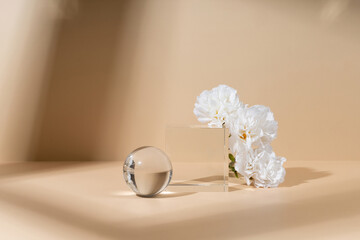 Skincare and cosmetic product showcase stand photography for online marketing include crystal ball and crystal cube stand on beige background with white flower