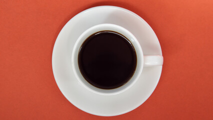 Black coffee in a white coffee cup on a bright background. Top view, flat lay, copy space. Cafe and bar, barista art concept. Freshly made natural or instant coffee in a cup. Coffee background.