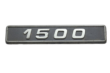 old car emblem. vintage plastic plate, showing engine displacement volume information in cubic centimeters. isolated on white background