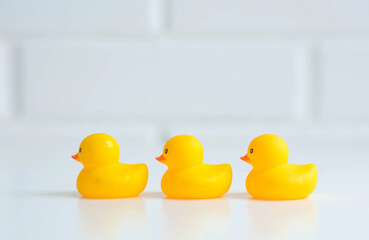 Baby bath accessories. Child care. Miniature yellow rubber ducklings for swimming on a white background.