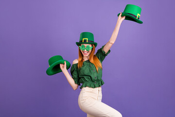 Photo of cute pretty young lady wear green blouse cap celebrating st patrick day holding headwears...