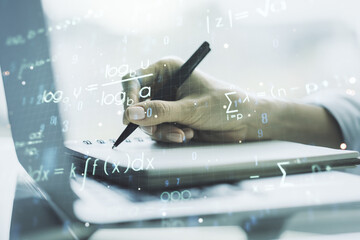 Double exposure of creative scientific formula concept with hand writing in notebook on background with laptop, research and development concept