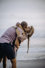 young beautiful couple in love walking at sunset by the ocean, couple relaxing in Bali, vacation in Bali, travel together, hug, love