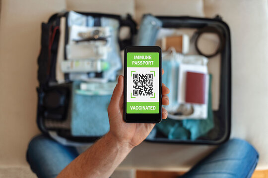 Unrecognizable man using digital passport on mobile for travel during COVID-19. Preparing for travel in new normal. Digital vaccine passport. International certificate of vaccination for coronavirus