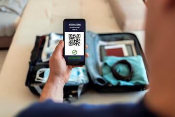 Unrecognizable man using digital passport on mobile for travel during COVID-19. Preparing for travel in new normal. Digital vaccine passport. International certificate of vaccination for coronavirus