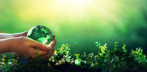 Earth Day.Hand holding crystal earth globe.Environment day, save clean planet, ecology concept.Renewable energy-based green businesses can limit climate change and global warming.