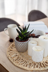 Planing in the morning. A cup of coffee, a bowl of chocolates and cookies, wireless headphones, note book, pen, candles and homemade flower on the table. The concept of planning and homeschooling.