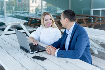a couple of the entrepreneurs gathered outside the office working on a project, checking data on the laptop