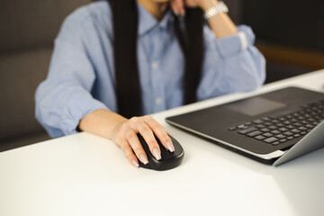 Freelancer girl clicking with wireless mouse. Entrepreneur woman working on laptop computer at home during lockdown. Free lance writer person doing distant work online