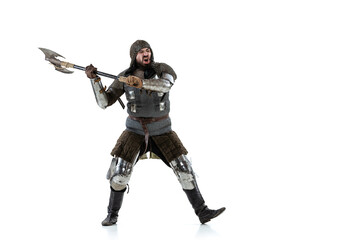Full-length portrait of brutal serious man, medieval knight swinging ax, ready to figth isolated over white studio background