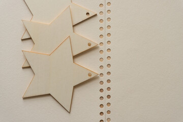 wooden star ornaments or shapes on paper with holes