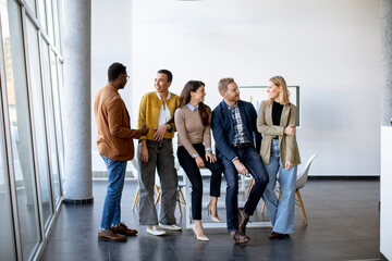 Group of positive businesspeople standing together in the office