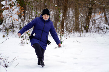 Fototapeta na wymiar woman walking in the snow, deep snow