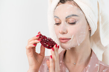 Face care and beauty treatments. Woman with a sheet moisturizing pomegranate mask on her face isolated on white background