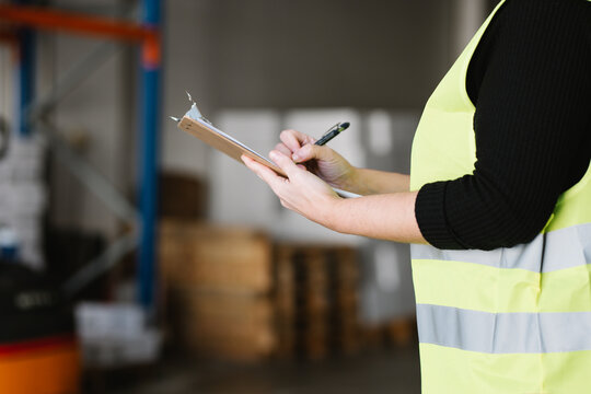 Anonymous woman taking notes while checking supplies