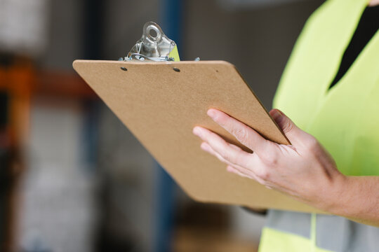 Anonymous woman taking notes while checking supplies