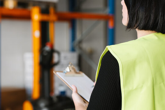 Anonymous woman taking notes while checking supplies