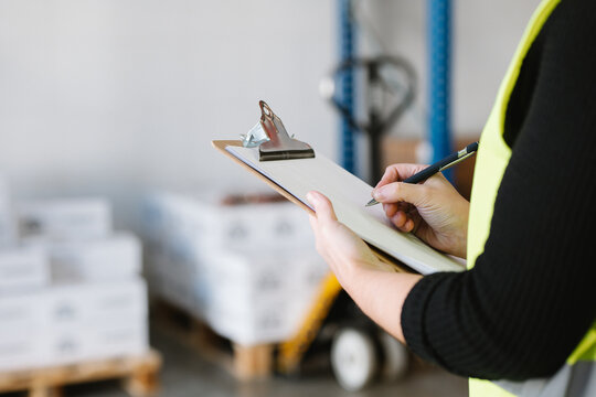 Anonymous woman taking notes while checking supplies
