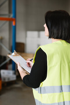 Anonymous woman taking notes while checking supplies