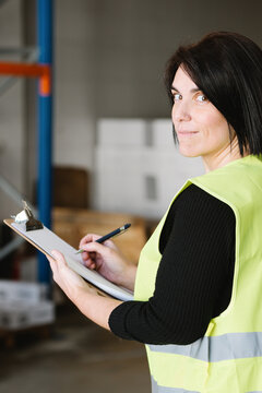 Woman taking notes while checking supplies