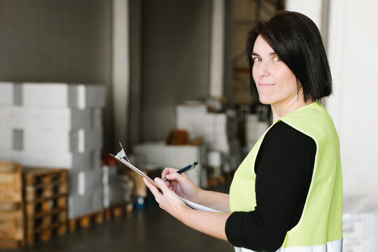 Woman taking notes while checking supplies