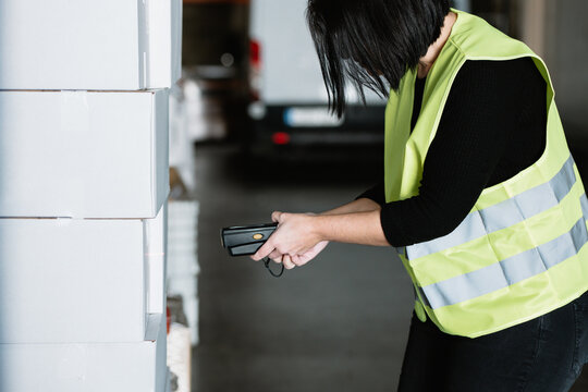 Unrecognizable woman scanning barcode on box