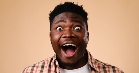 Surprise and excited young man over beige background