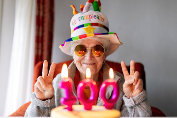 Cheerful elderly woman celebrating birthday with cake