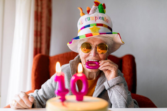Happy aged woman celebrating hundredth birthday at home