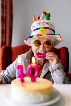 Happy aged woman celebrating hundredth birthday at home