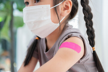 Close-up of medicinal plaster after vaccinated in shoulder of Asian girl kids in hospital. Pediatrician makes vaccination for kids. Vaccination, immunization, disease prevention concept. - obrazy, fototapety, plakaty