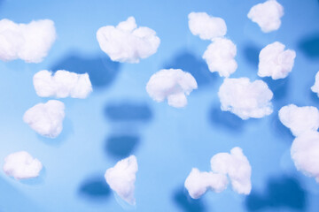 White cotton fake clouds on a pastel blue background.