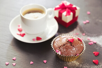 Cup of coffee, chocolate muffins and gift.