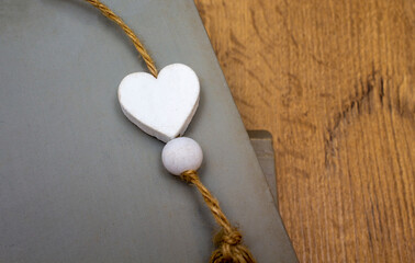Wooden heart on grey books on wooden background. Love valentine concept