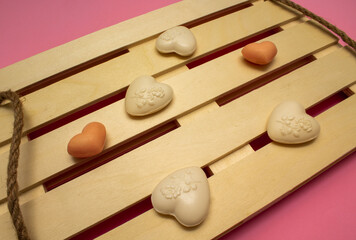 Heart-shaped soap on palette as tray on pink background. Love valentine concept