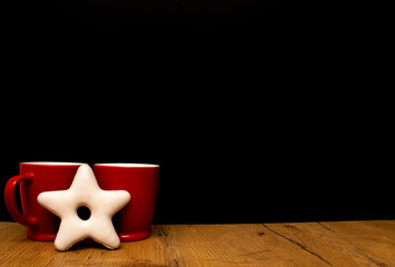Coffee red cups on black background with star shape cookie. Coffee and love concept.
