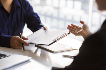 Applicants submit resumes and job interviews. Businessman holding a resume is interviewing for a job in the office.