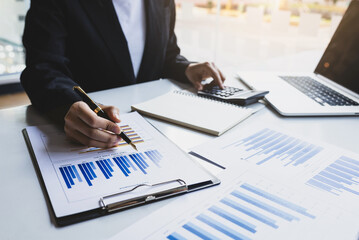Businessman analyzing investment charts with laptop and calculator. Concept of business analysis and financial accounting planning.