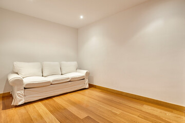 Fototapeta na wymiar Empty white room with sofa and parquet floor. Apartment indoor
