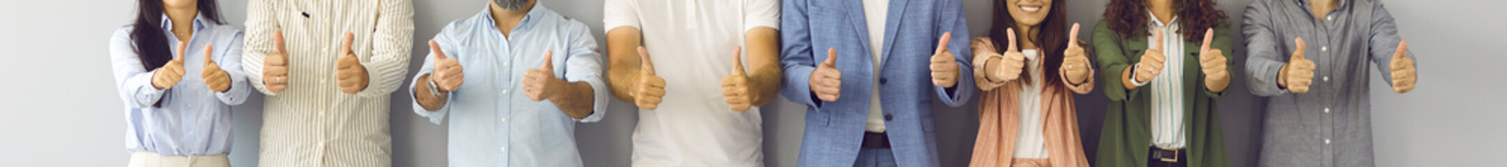 Happy business team doing thumbs up all together. Banner background with midsection shot of group...