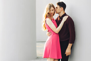 Beautiful romantic couple, woman in a dress and a handsome man are hugging and looking at each other. Valentine's Day