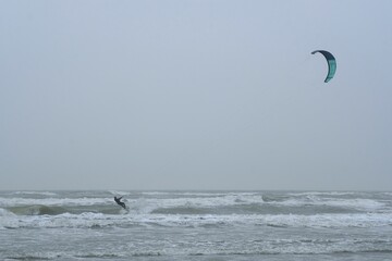 kitesurfers at sea suring a storm at a dutch beach