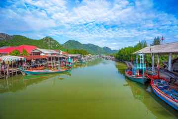 Two small traditional fishing boats, sea and hillside views, fish cages, blue sea and sky with copyscape, fishing boats floating on the water