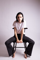 woman in white t-shirt sits on a chair