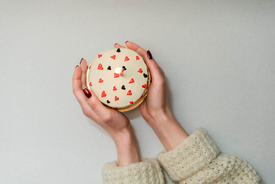 Woman holding Bento Cake. Portioned trandy dessert for one person in eco box with purple ribbon, small cake.