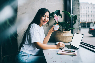 Ethnic lady remote worker using computer at cafe